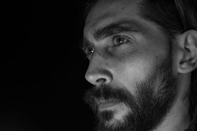 Close-up portrait of young man against black background