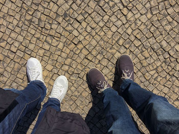 Low section of man standing on cobblestone