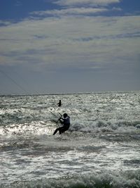 Man surfing on sea against sky