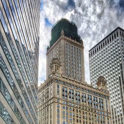 Low angle view of modern building against cloudy sky