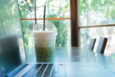Close-up of drink by laptop on table