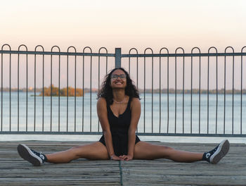 Full length portrait of woman sitting outdoors