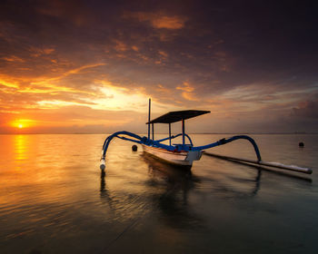 Nautical vessel on sea against sky during sunset