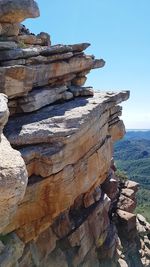 Rock formations on shore against clear sky