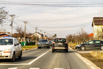 Cars on road against sky in city