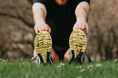 Low section of man standing on grass while exercising