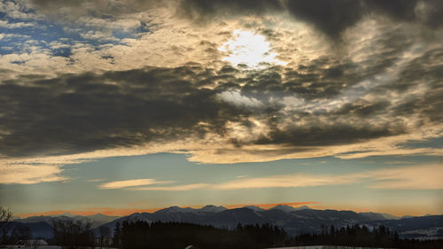 Scenic view of silhouette mountains against dramatic sky