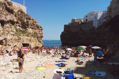 People at beach against clear sky