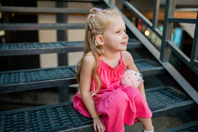 Young woman sitting on railing