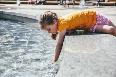 Girl looking away while standing in water