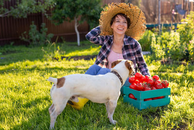 Portrait of a smiling young woman standing against plants