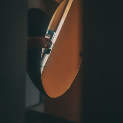Close-up of person holding illuminated lamp at home