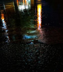 Reflection of illuminated water in puddle