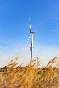 Windmill on field against sky