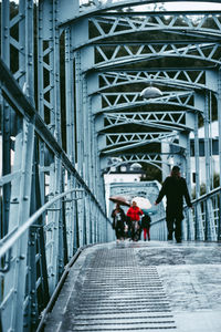 Rear view of man walking on bridge