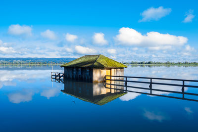 House by sea reflection against sky