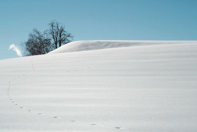 Scenic view of snow covered land against clear sky