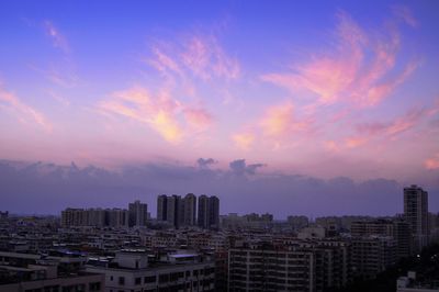 View of cityscape against cloudy sky during sunset