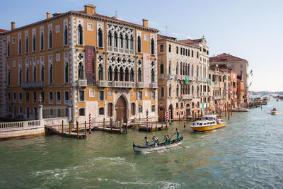 Boats in canal along buildings