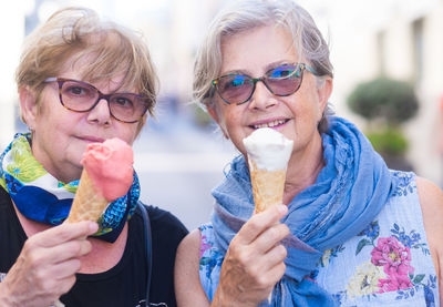 Portrait of female seniors friends holding ice cream
