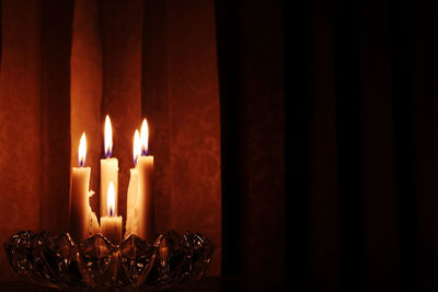 Close-up of burning candles in dark room