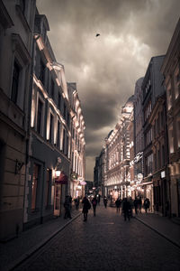 People walking on street amidst buildings in city