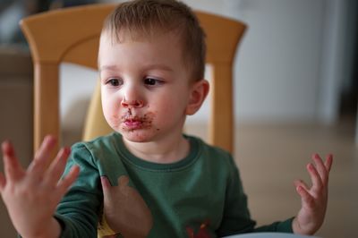 Cute little toddler smeared with chocolate around his mouth