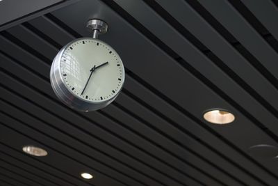 Low angle view of clock hanging on ceiling