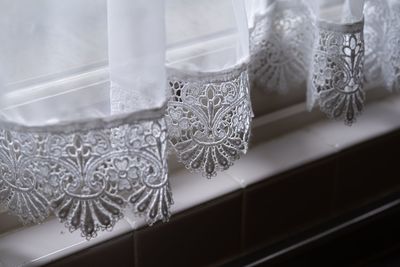 Close-up of curtain on glass table at home