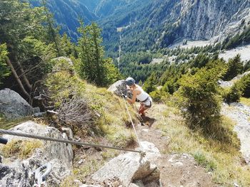 Full length of woman climbing on mountain at via ferrata, heini-holzer-klettersteig, merano