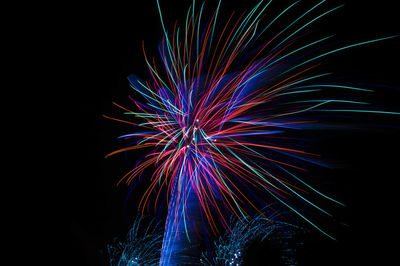 Low angle view of firework display over black background