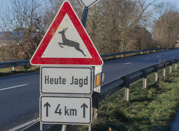 Close-up of road sign against trees