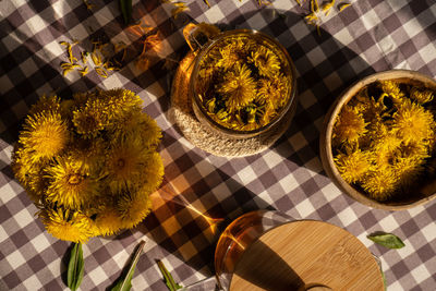 Dandelion flower healthy tea in glass teapot and glass cup on table. delicious herbal hot tea from