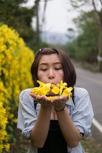 Beautiful young woman holding yellow flower
