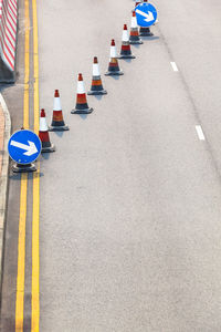 High angle view of arrow symbol traffic cones on road in city