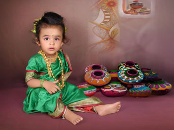 Portrait of cute girl sitting on sofa at home