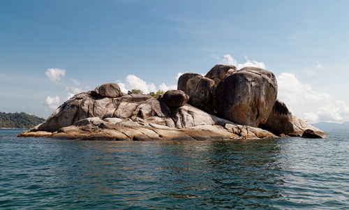 Rock formations by sea against sky