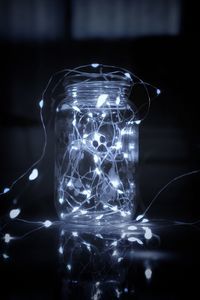 Close-up of illuminated light bulb on table