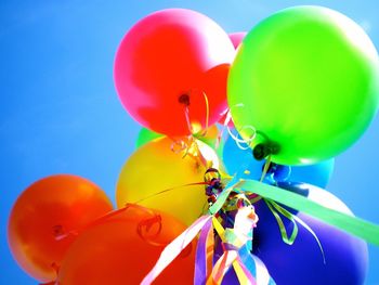 Low angle view of balloons against blue sky