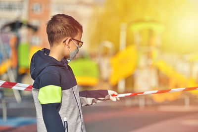 Side view of young man holding umbrella