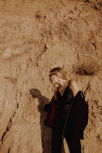 Side view of woman standing on rock