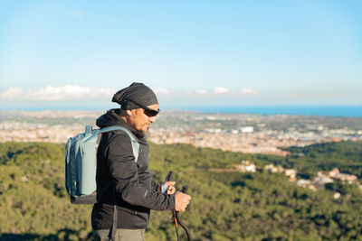 Rear view of man standing on field against sky