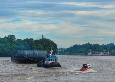 Boat sailing in sea against sky