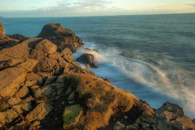 Scenic view of rocks on beach against sky