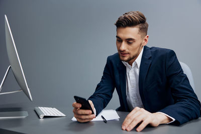 Businessman using smart phone at desk