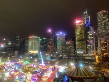 Illuminated city buildings against sky at night