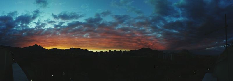 Silhouette buildings against sky at sunset