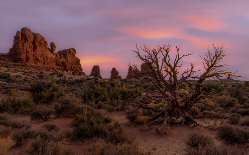 Rock formations on landscape against sky during sunset