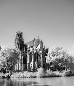Buildings by lake against clear sky