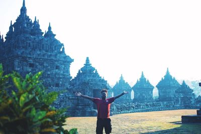 Man standing in front of temple against clear sky